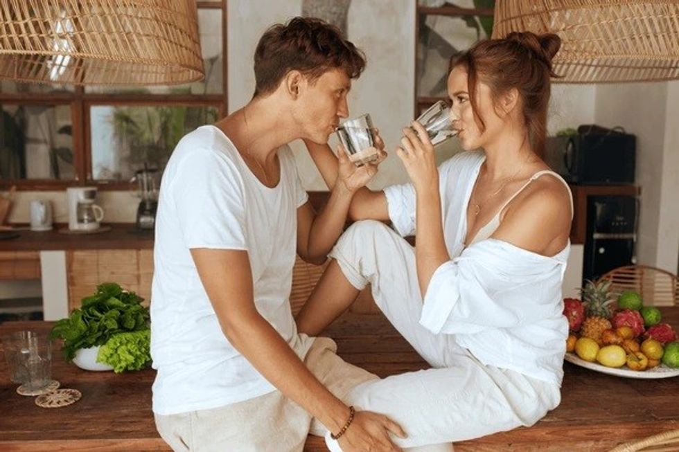 romantic couple drinking water kitchen 600nw 1788238196