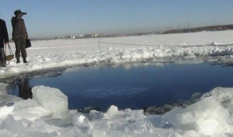 Russian police work near an ice hole at lake Chebarkul, said by the Interior Ministry department for Chelyabinsk to be the point of impact of a meteor