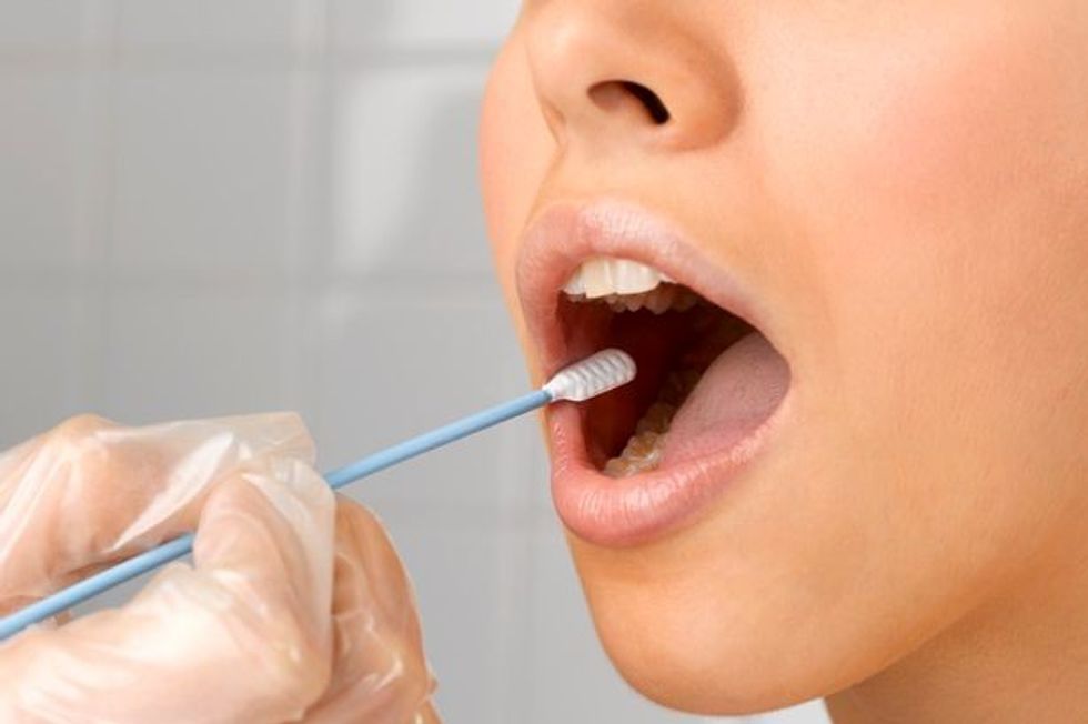 Saliva taken from womans mouth for medical test