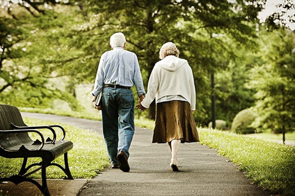 Senior couple walking in park.