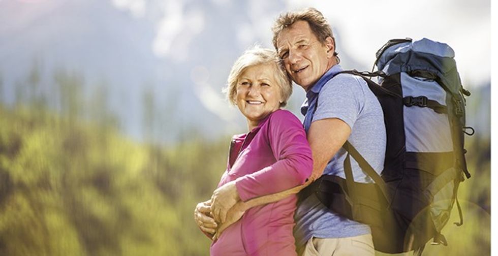 Senior tourist couple hiking at the beautiful mountains