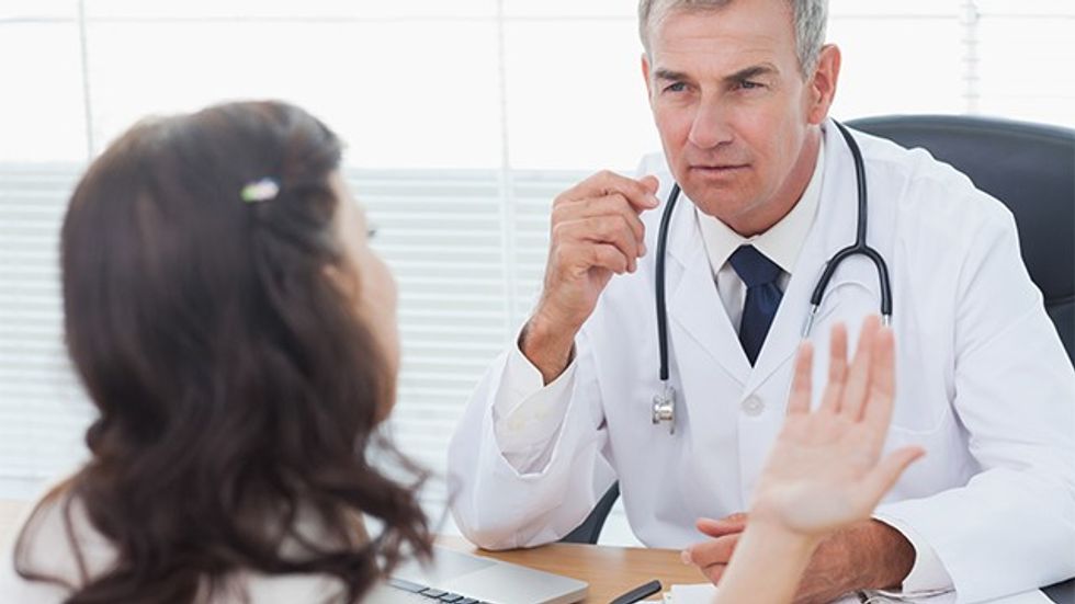 Serious doctor listening to his patient talking