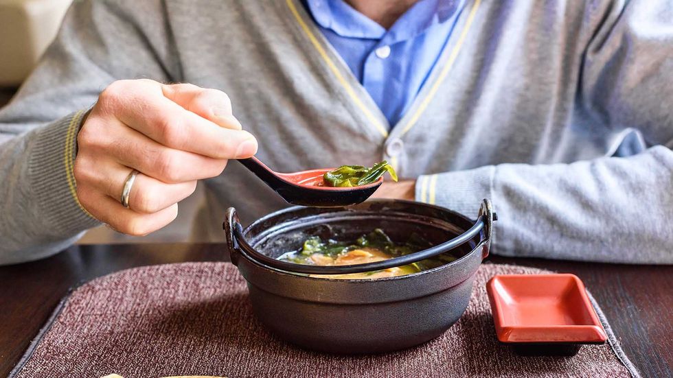 sick man on couch drinking tea