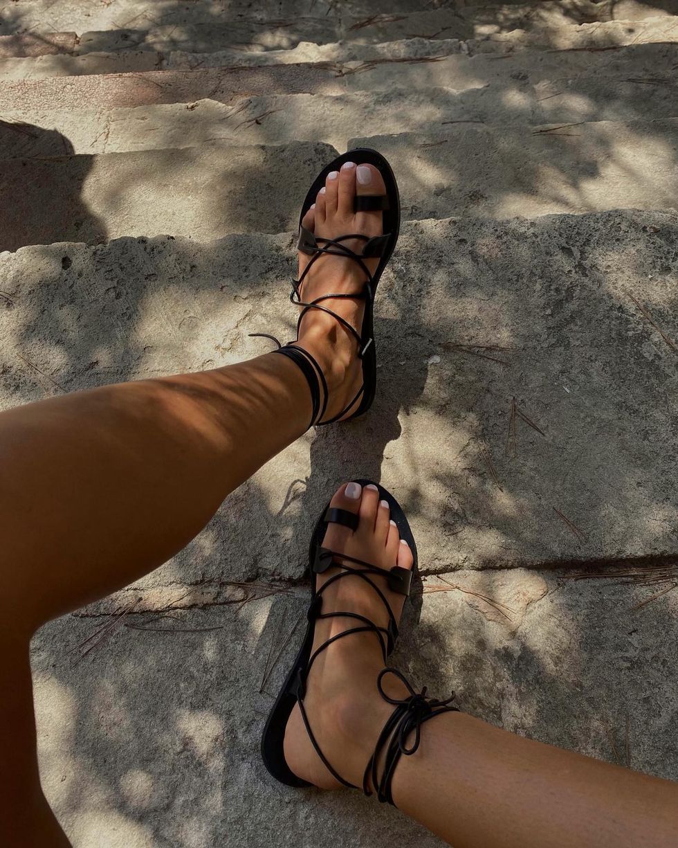 @smythsisters wearing black sandals with a milky pedicure