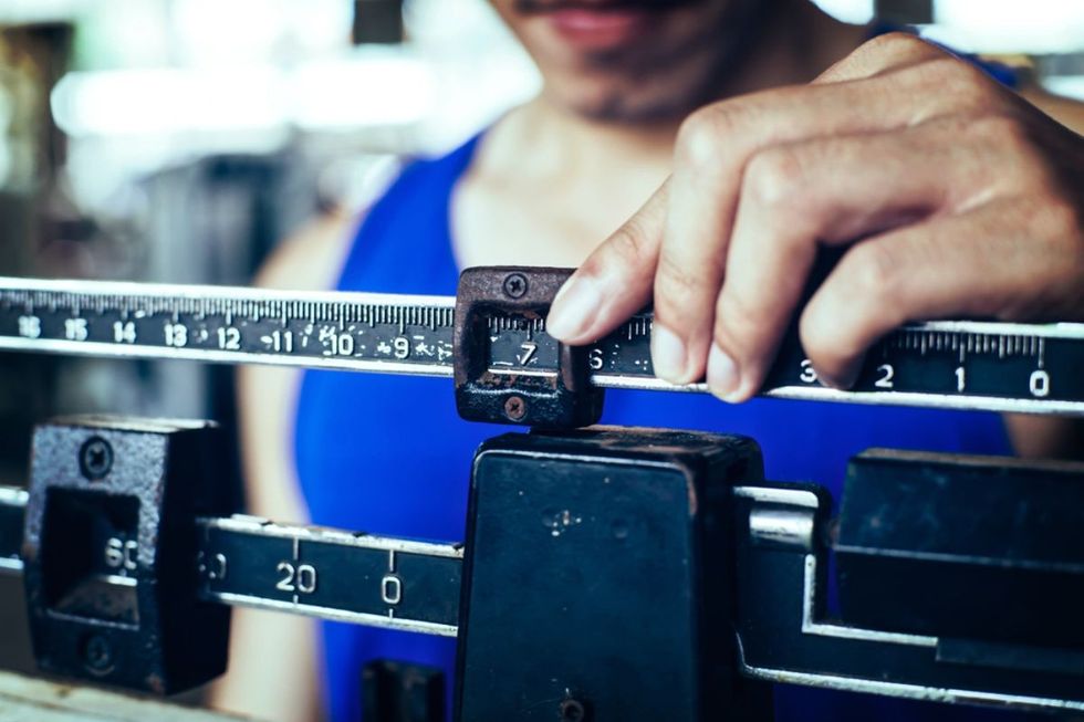 sport man weighing himself on balance gain weight ss