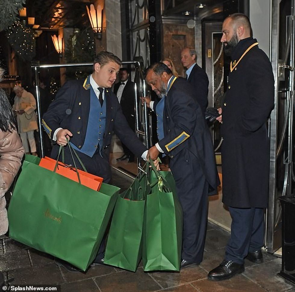 Stafi i hotelit u pa duke ngarkuar bollëkun e çantave të blerjeve në një karrocë bagazhesh për t'i futur brenda