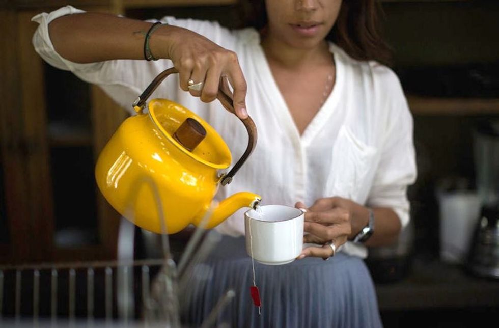 Stocksy woman pouring tea Linzy Slusher