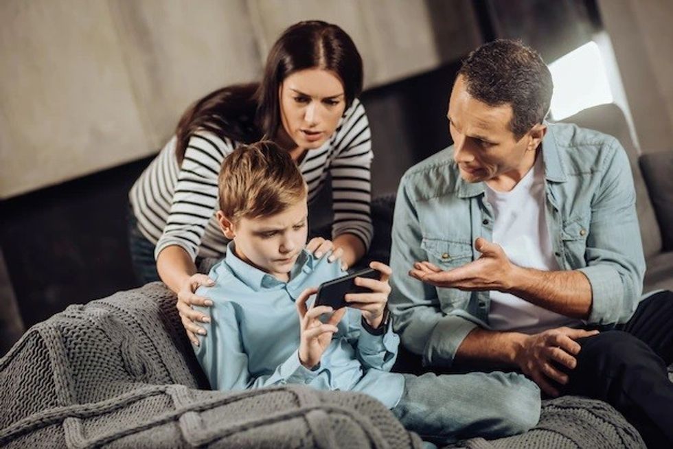 stop playing loving young parents standing near their pre teen son convincing him put down phone while boy refusing being stubborn 259150 26002
