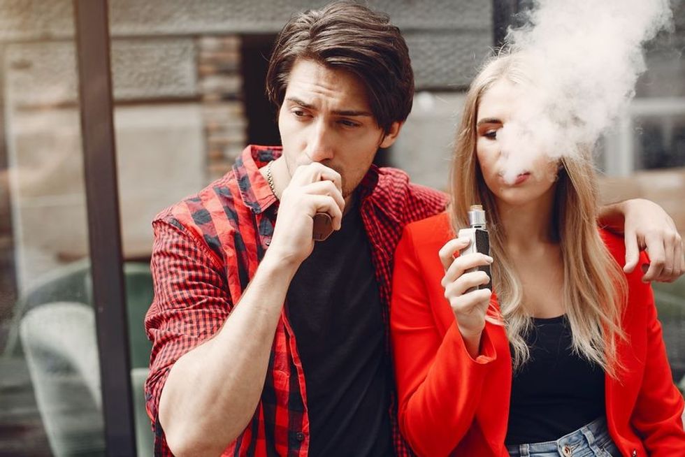 stylish young couple with vape in city