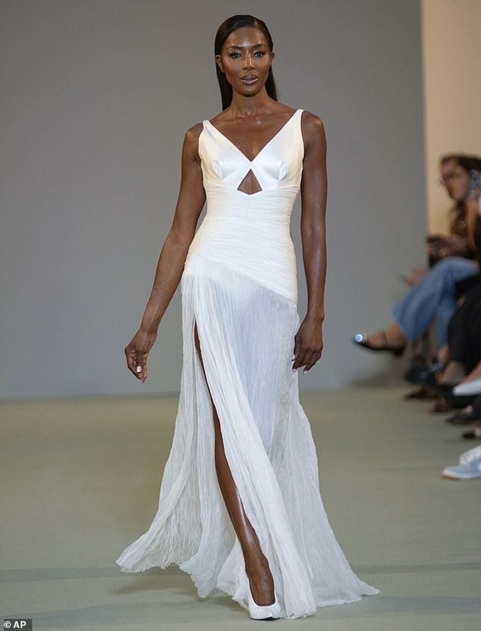 Supermodelja, 54 vjeçe, tregoi figurën e saj të mahnitshme me fustanin prej sateni me jakë V, i cili vinte poshtë në një fund maxi të zhveshur.