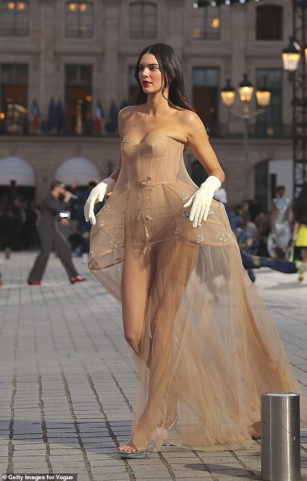 Supermodelja ka veshur një ekran këmbëgjatë në fund elegante gjysmë të tejdukshme me këllëf