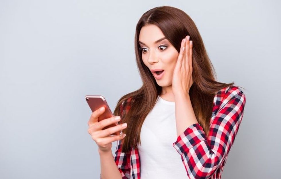surprise message cell phone woman