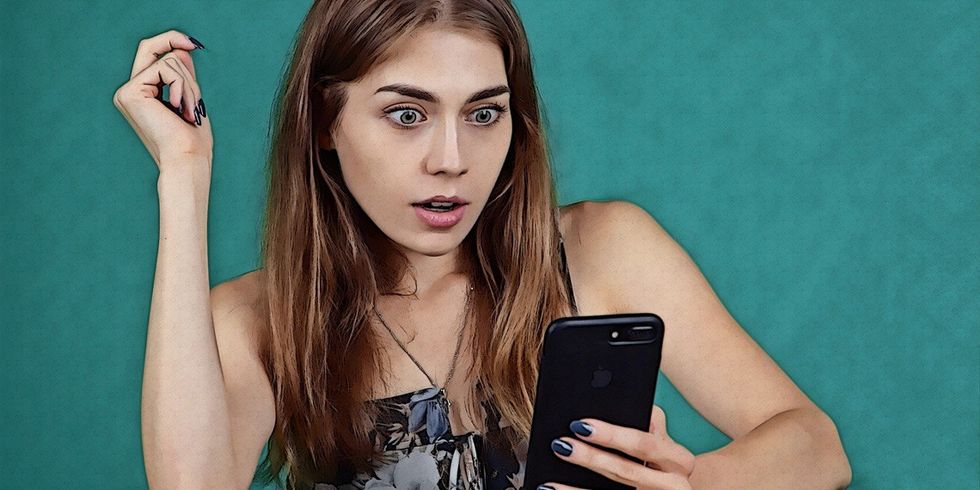 surprised woman looking at her smartphone