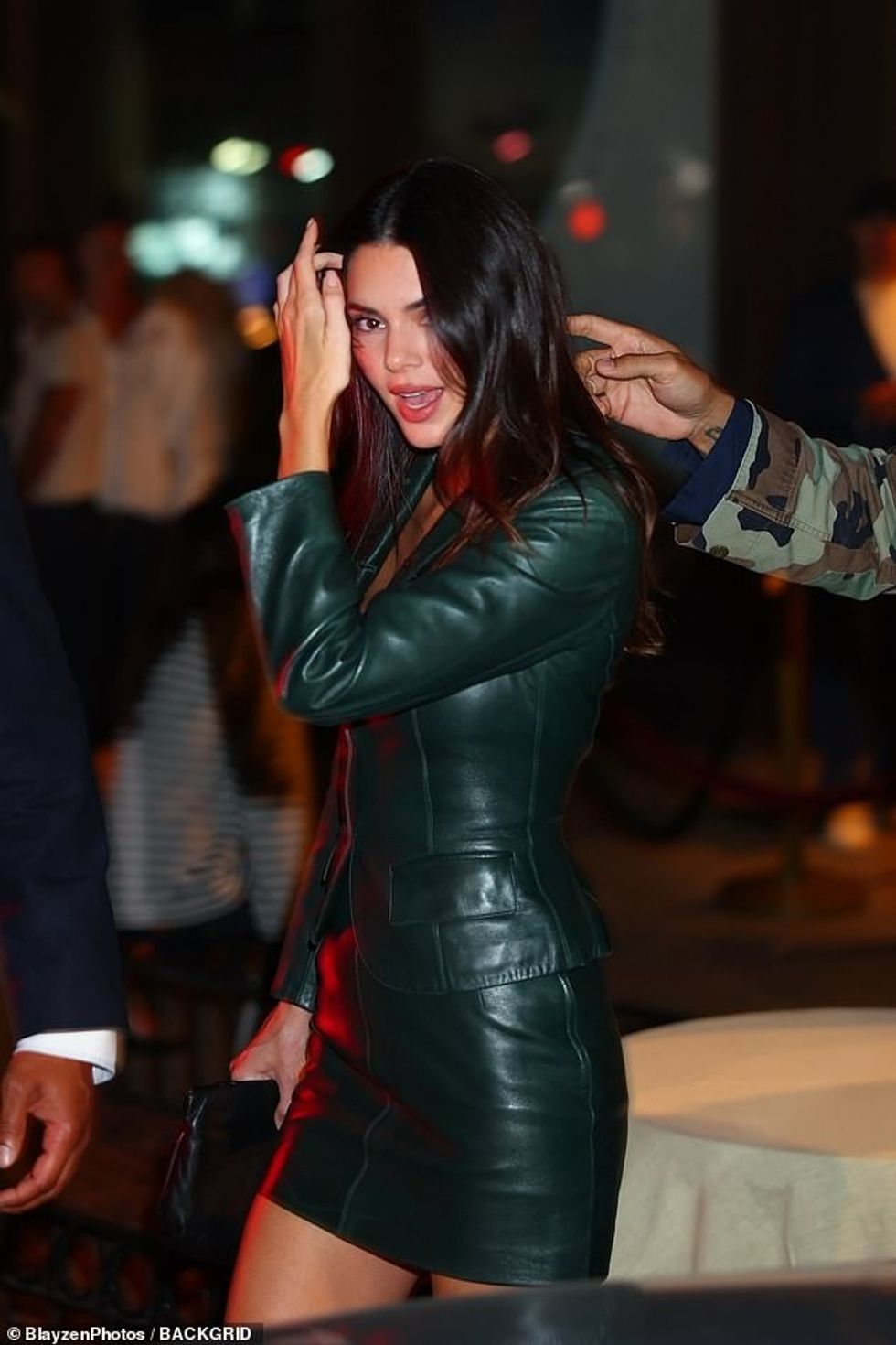 The supermodel, 28, looked typically stylish on the night out, slipping into a daring green leather mini skirt and matching blazer