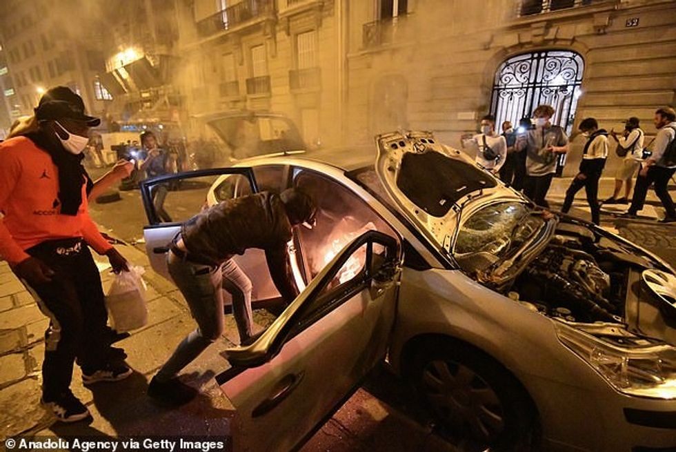 They were seen placing burning objects into the vehicle as it stood parked on a quiet side-street before bursting into flames