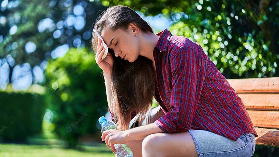 tired sweating woman with water bottle resting bench wipes her forehead with napkin park summer hot weather 122732 3186