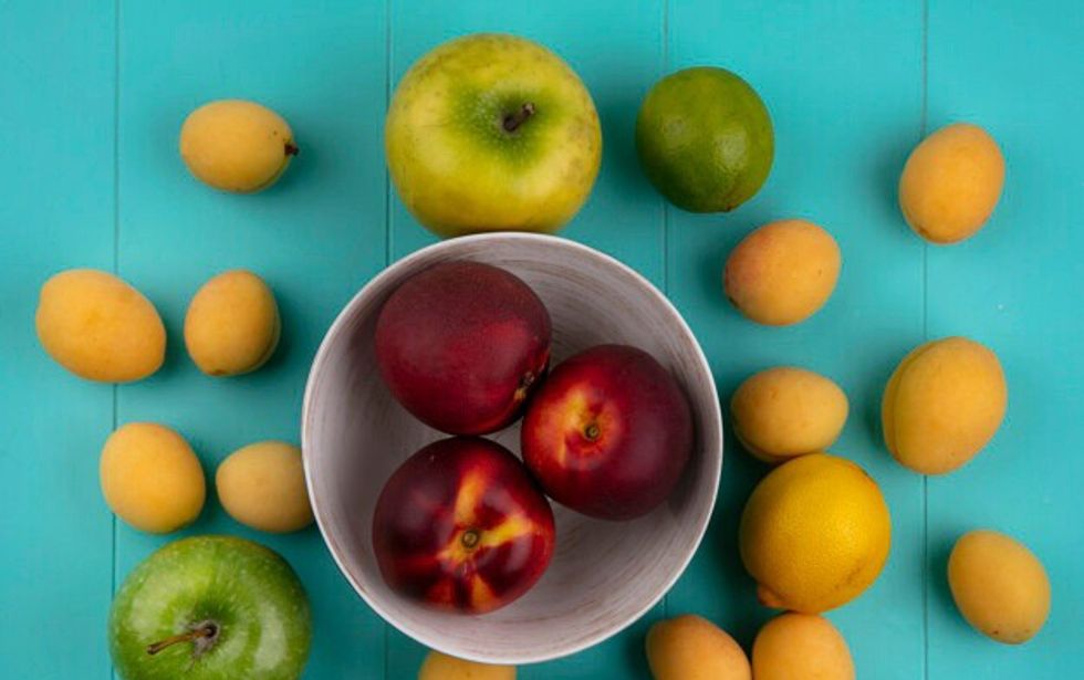 top view peaches bowl with apples apricots lemon lime blue surface 141793 18318