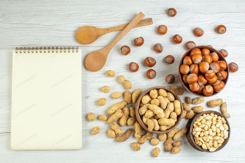 topviewdifferentnutspeanutshazelnutsandwalnutsonwhitebackgroundphotosnackcolornutseedmovie