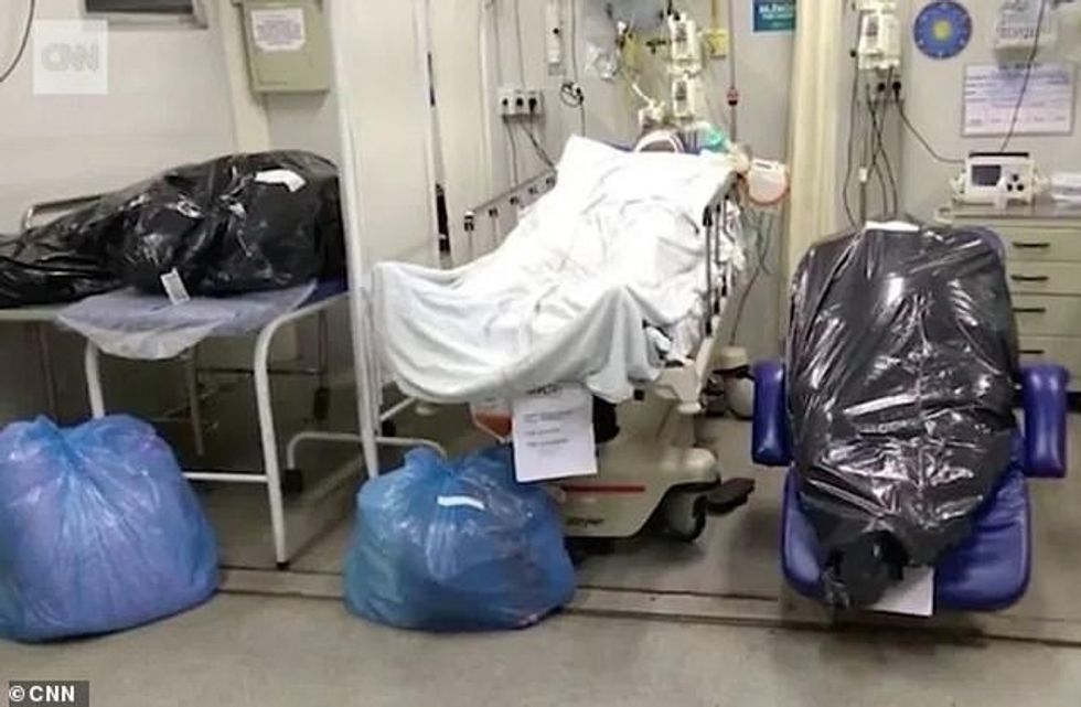 Two bodies of coronavirus victims are seen stuffed in bin bags lying next to a patient in a hospital in Rio de Janeiro as the killer virus continues to cause havoc in Brazil
