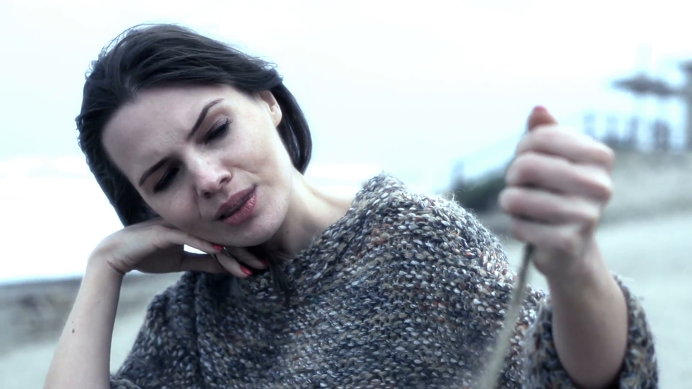 unhappy sad woman sitting on beach during stormy day noevl4ob3x F0000