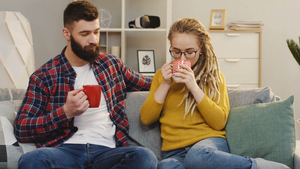 videoblocks attractive hipsters woman and man drinking a tea or coffee while sitting on the sofa at home and talking portrait shot indoors r5rk9fkfm thumbnail full01