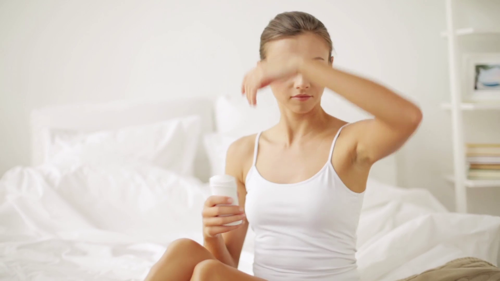 videoblocks beauty hygiene bodycare and people concept young woman applying antiperspirant or stick deodorant at home bedroom rioq1wire thumbnail full01