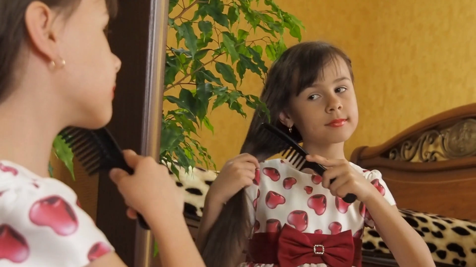 videoblocks the girl at the mirror with painted lips the little girl is combing her hair the child at the mirror h6vuz p