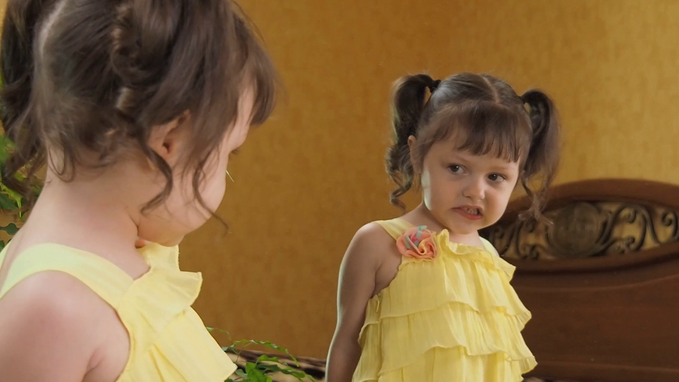 videoblocks the little girl in front of the mirror bites her lip a beautiful child in a yellow dress by the mirror girl