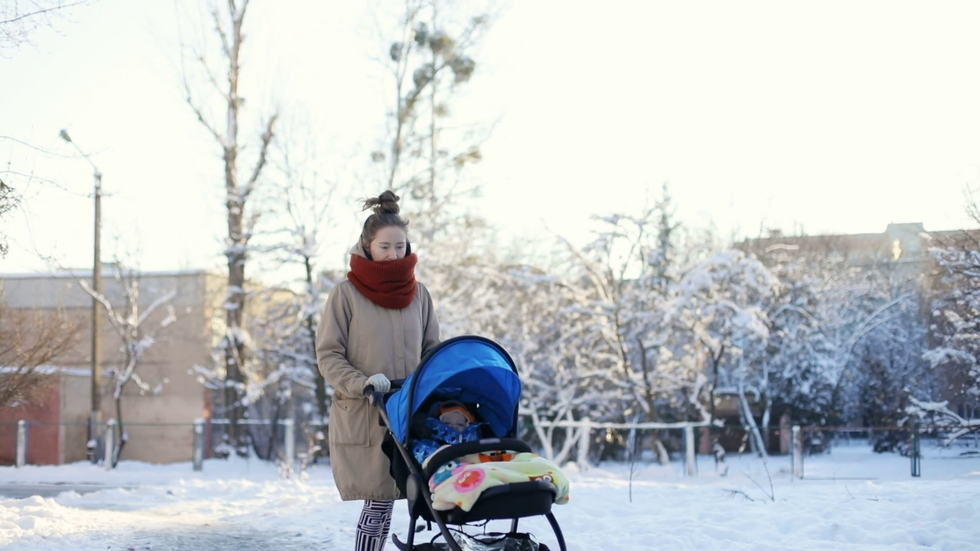 videoblocks young mother walking with baby carriage on the winter snowy street
