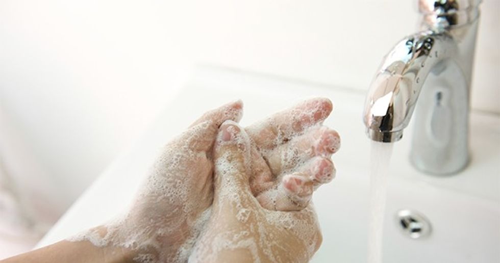 Washing of hands with soap under running water.