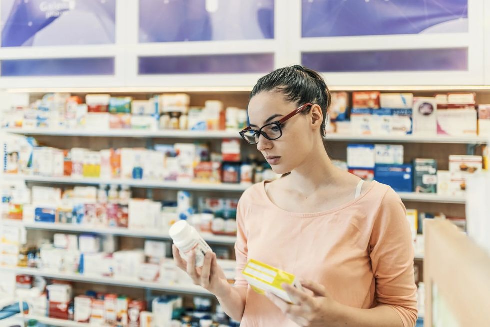 Woman Choosing Over the Counter Medication at the Drugstore