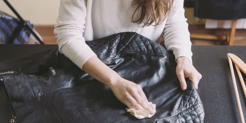 woman cleaning leather jacket royalty free image 1671719412