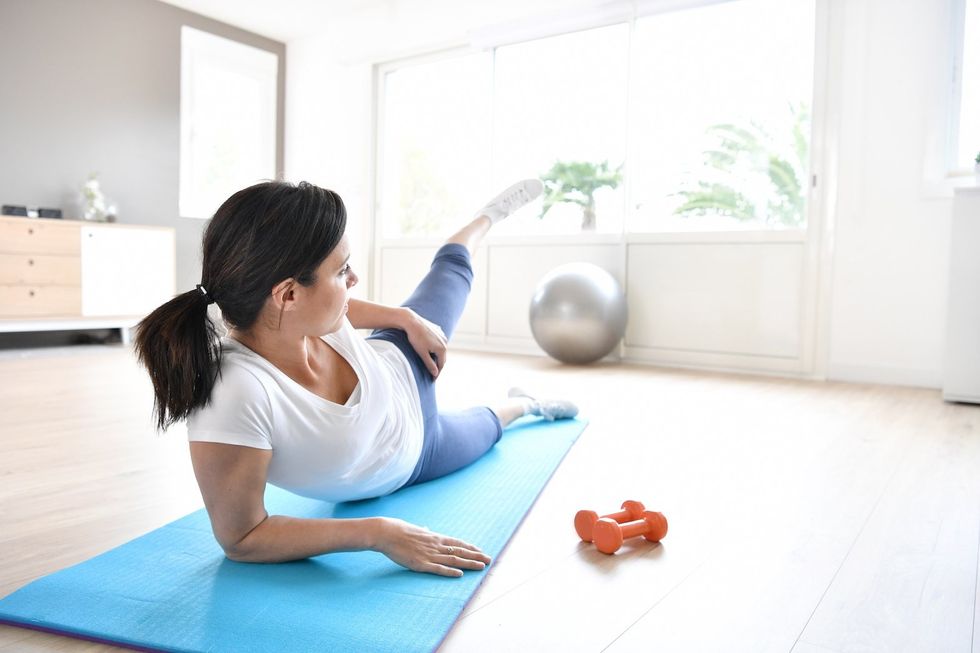 woman doing leg lifts blue white home workout
