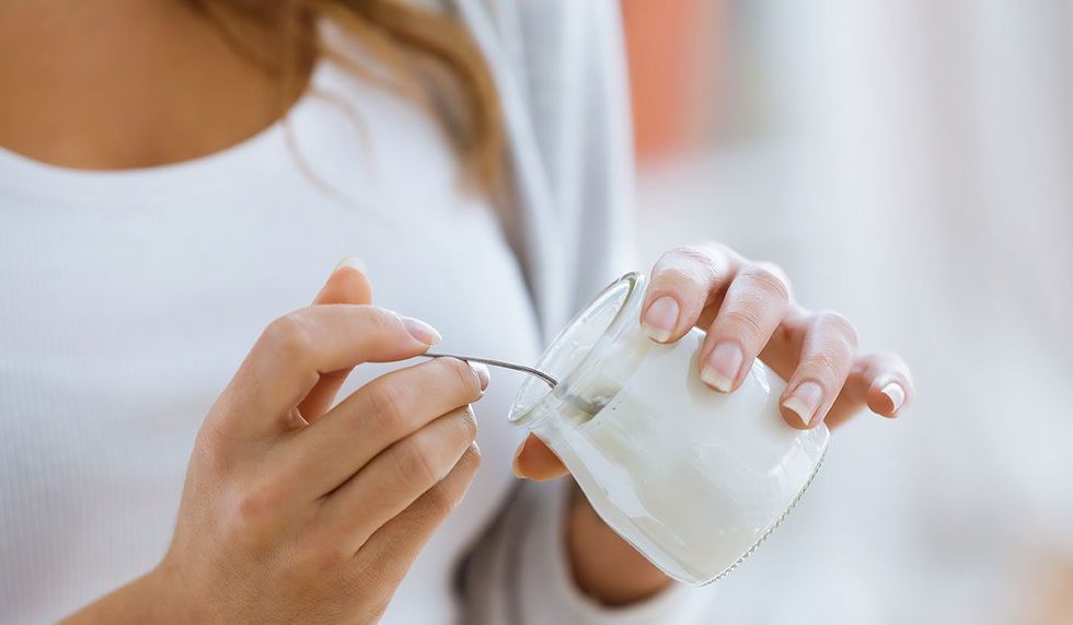 woman eating greek yogurt hands