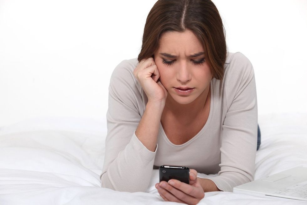 woman getting bored of sms from a guy