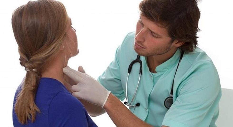 woman getting neck looked at by doctor