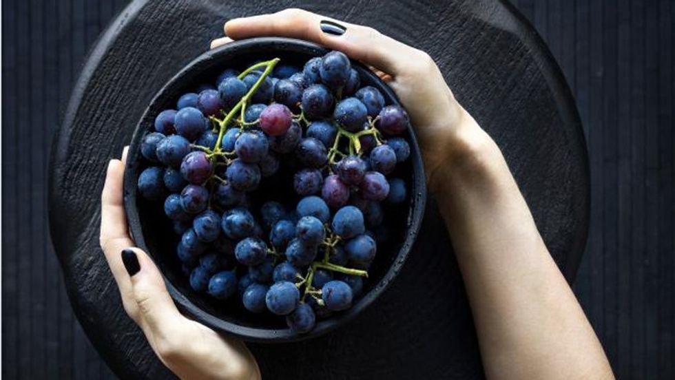 woman holding bowl grapes