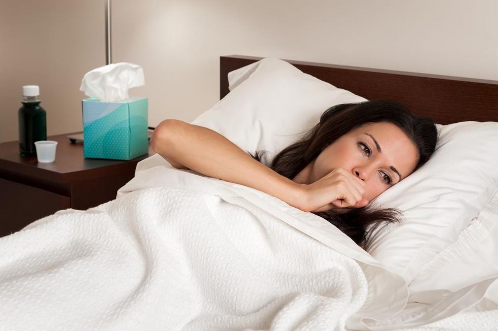 woman in bed with the flu with difficulty breathing