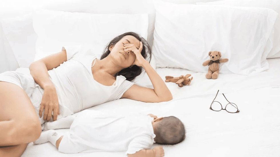 woman laying with baby in