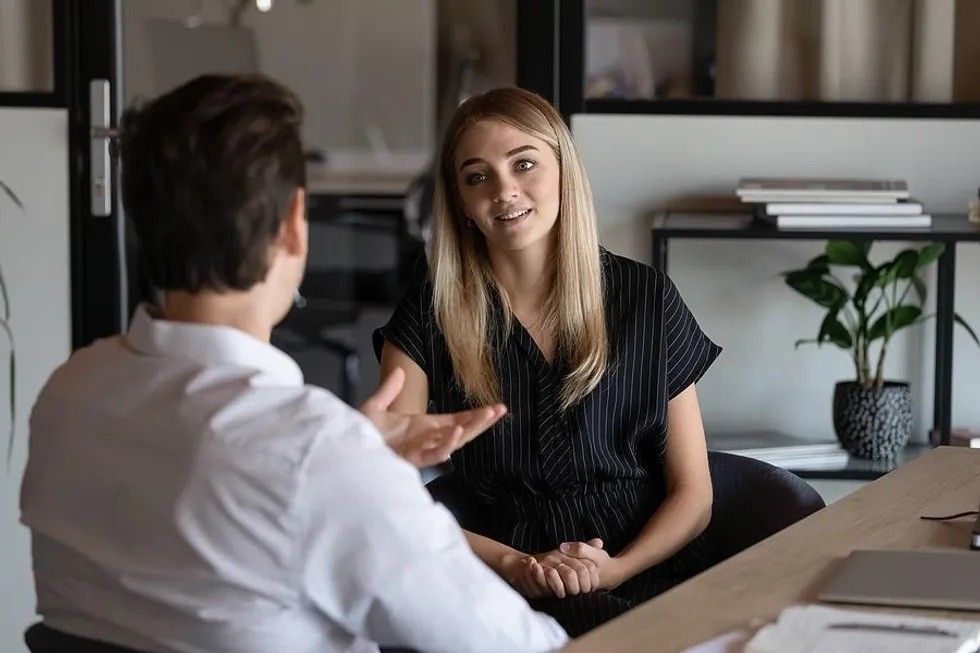 woman listens to the hiring manager during a job interview