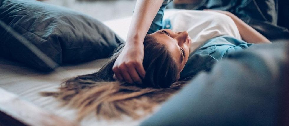 woman lying on her bed with fatigue due to hepatitis c symptoms