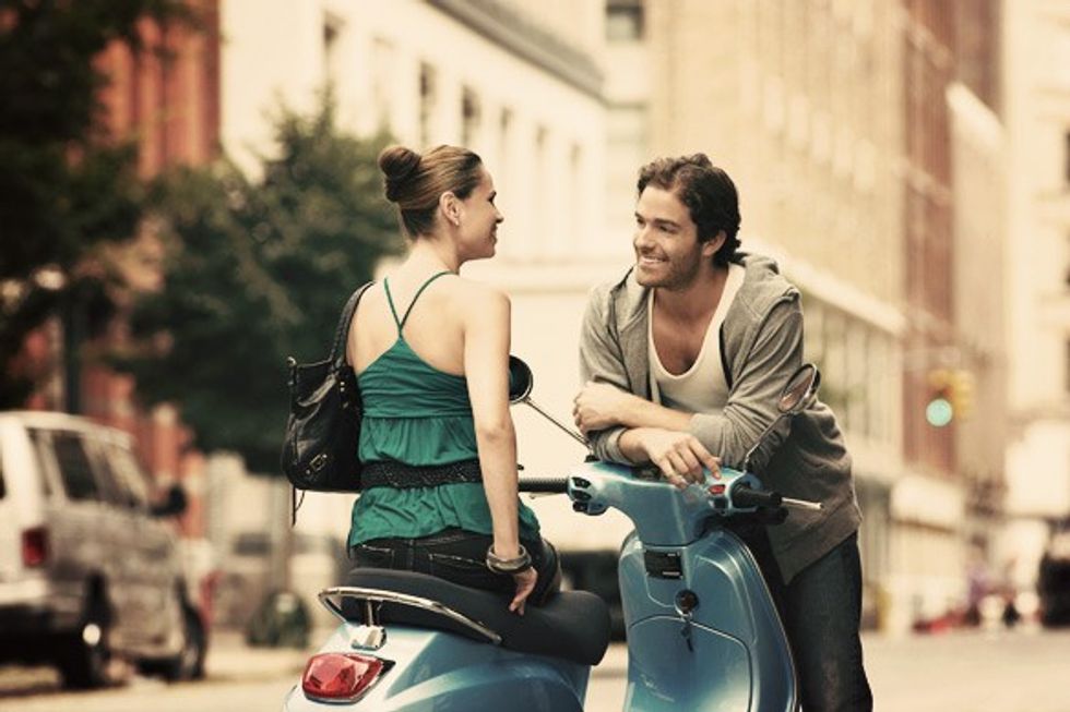 Woman-on-moped-talking-to-man-in-street