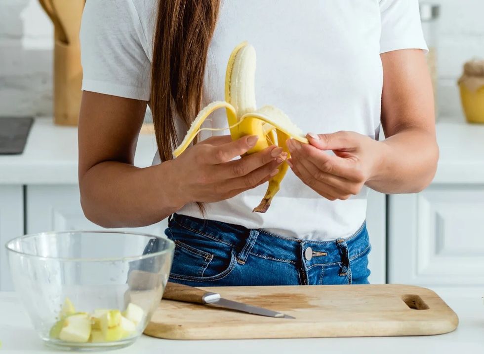 woman peeling cutting banana