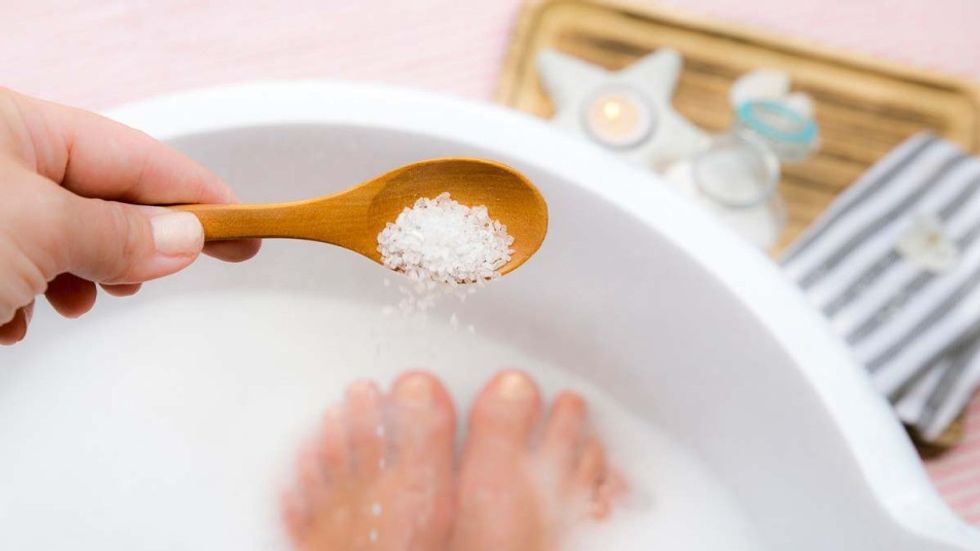 Woman pouring epsom salt in a bath