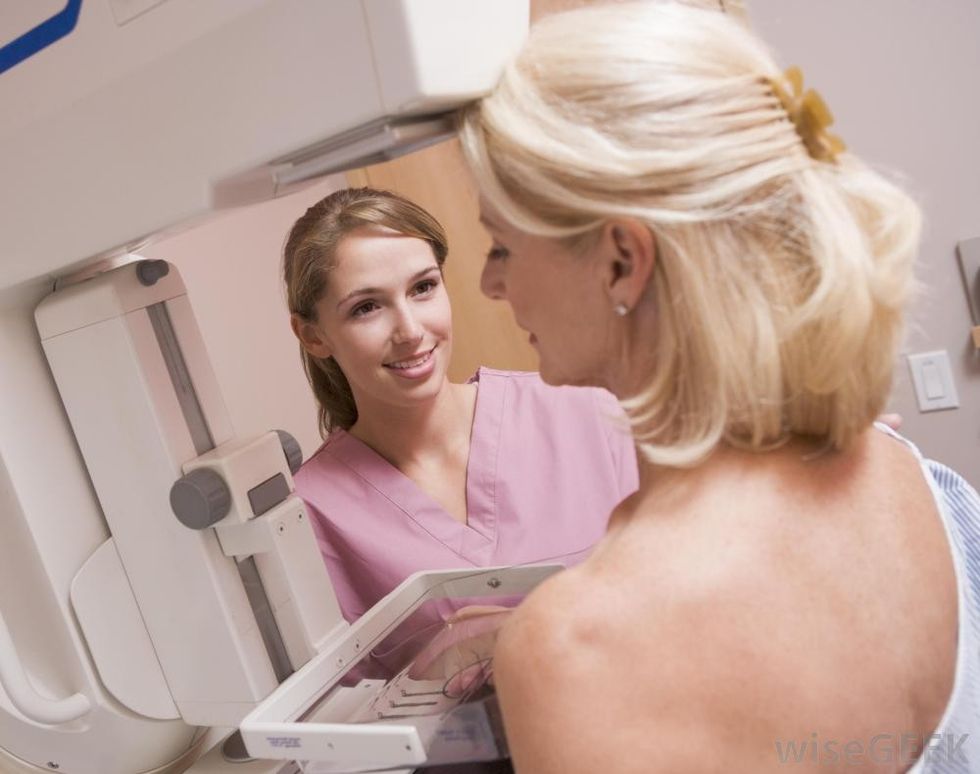 woman receiving mammogram near woman in pink scrubs