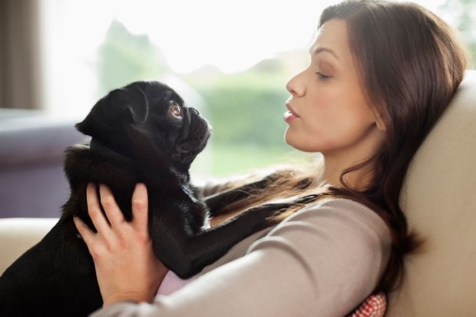 Woman relaxing with dog on sofa