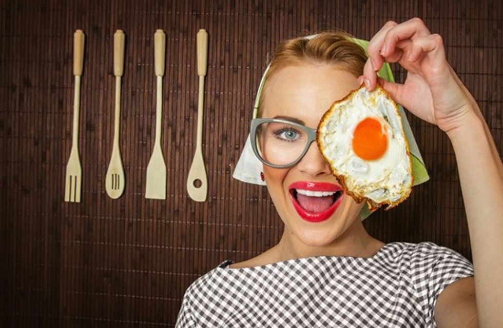 woman smiling holding a fried egg