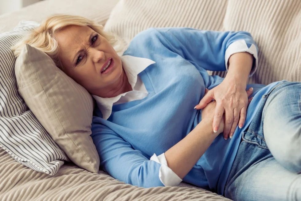 woman stomach pain sofa