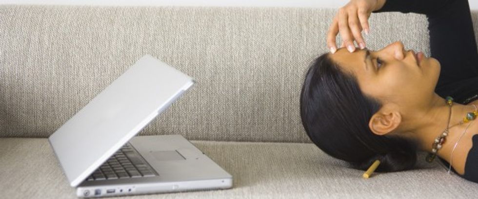 Woman with headache and laptop