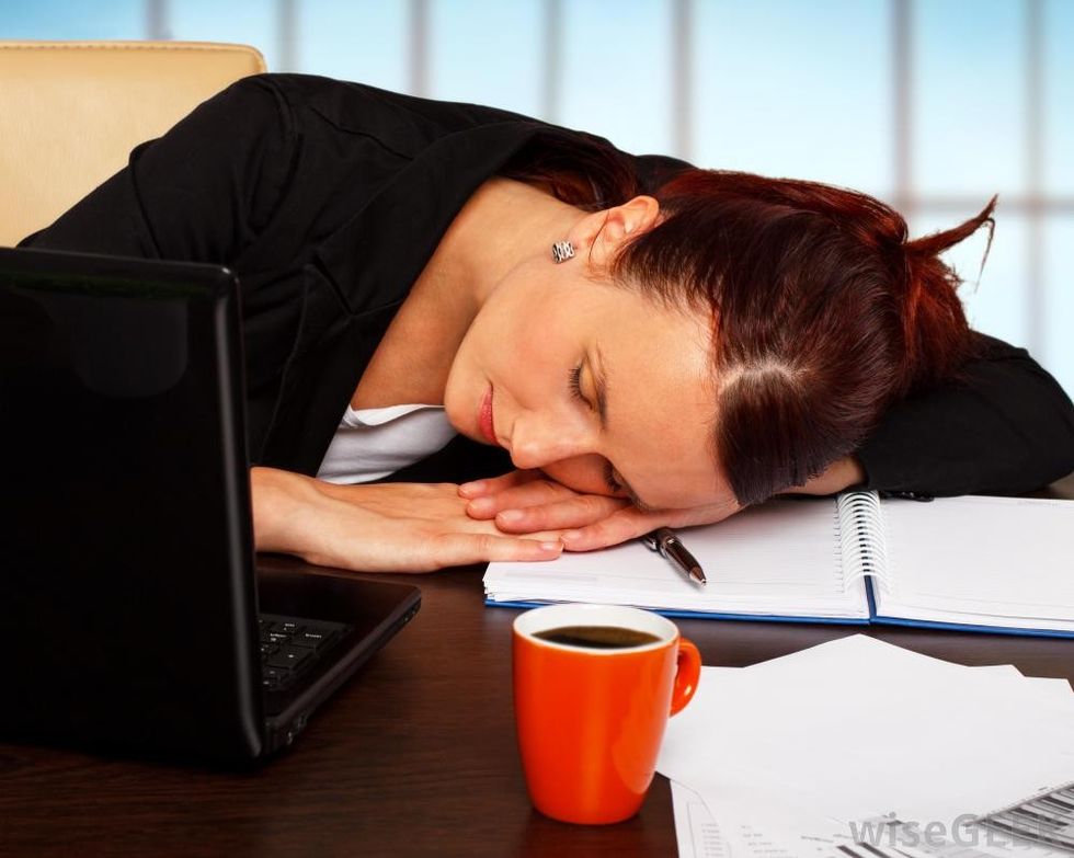 woman with red hair in suit asleep at desk